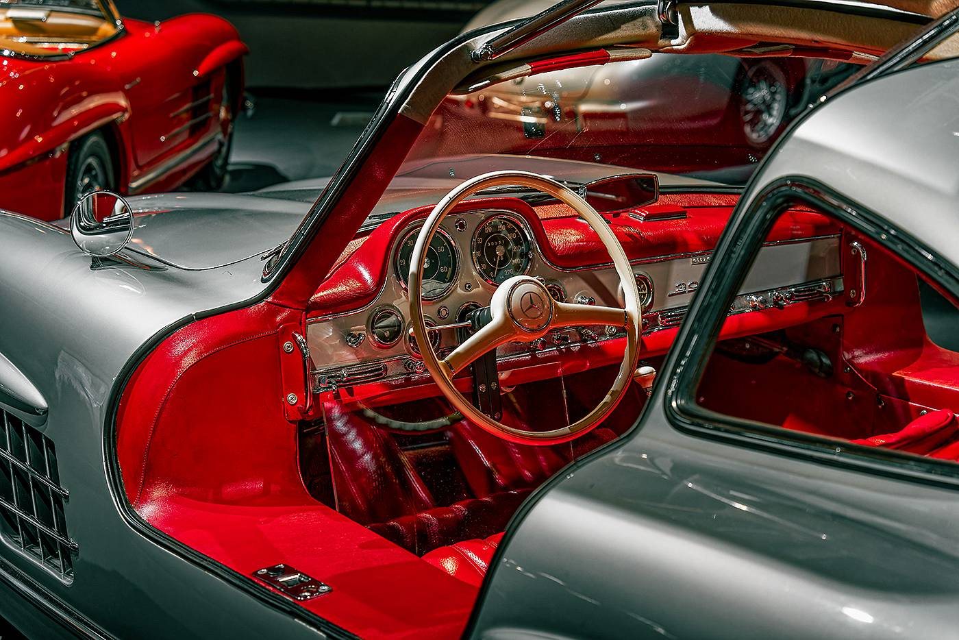 Silberner Mercedes 300 SL mit roter Innenausstattung