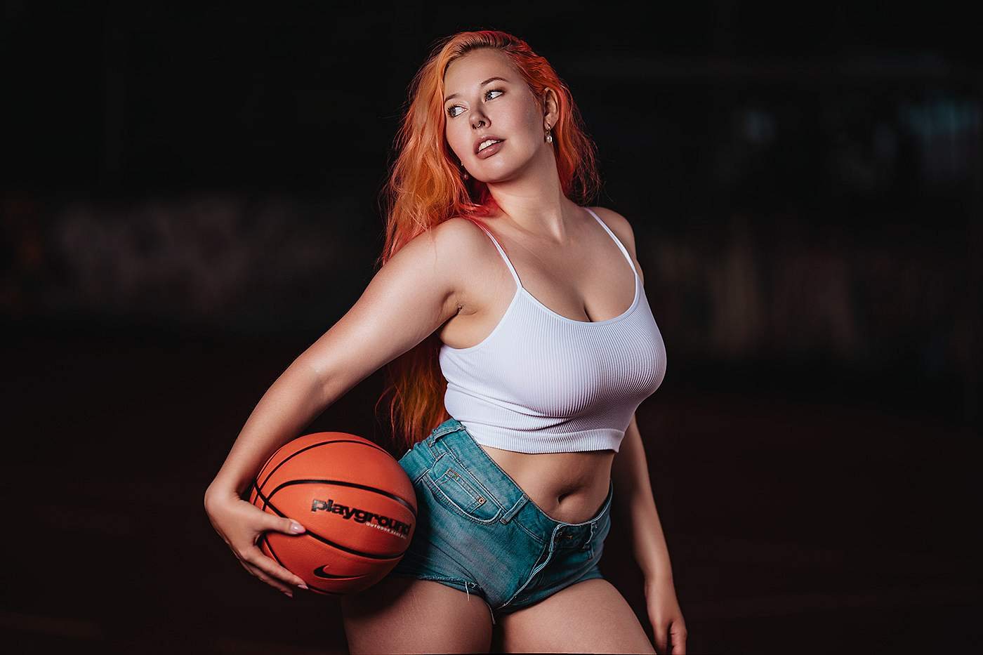 Frau mit roten Haaren und Basketball auf dem Platz